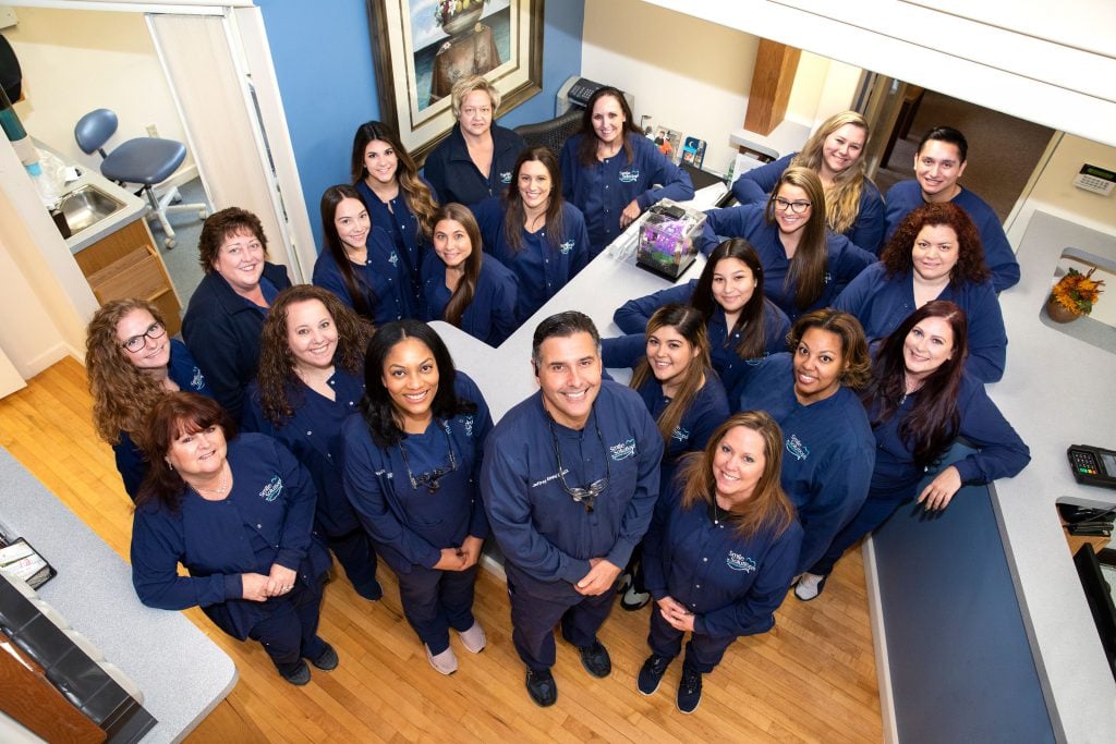 The entire smile solutions staff posing from below